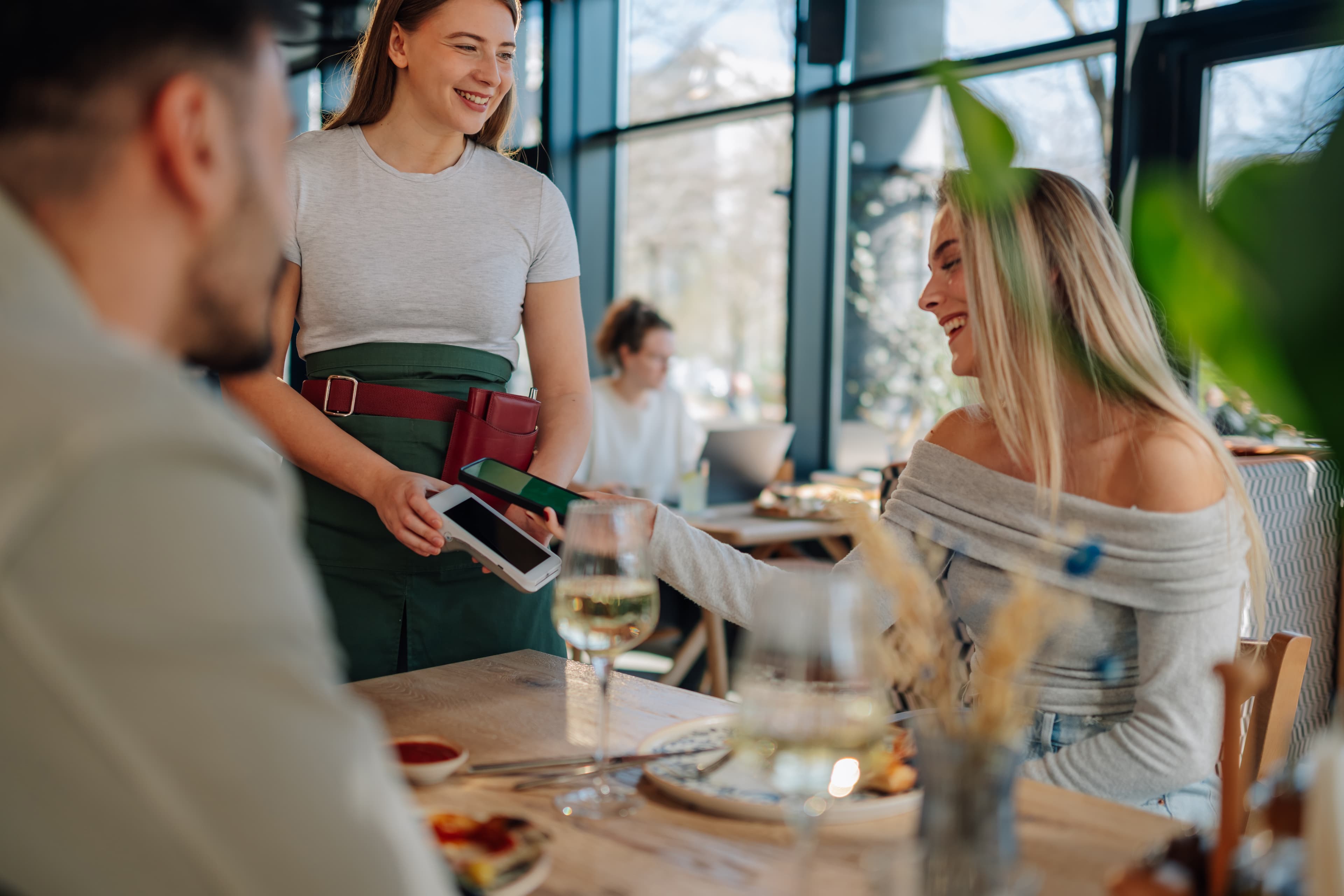 Waitress using POS device to take payment